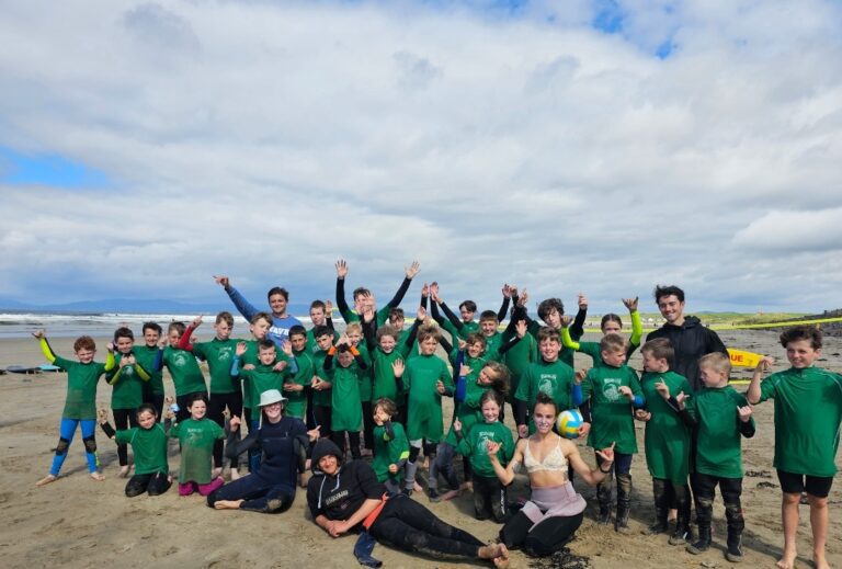 Group of children participating in summer surf camp with instructors at Rossnowlagh Beach