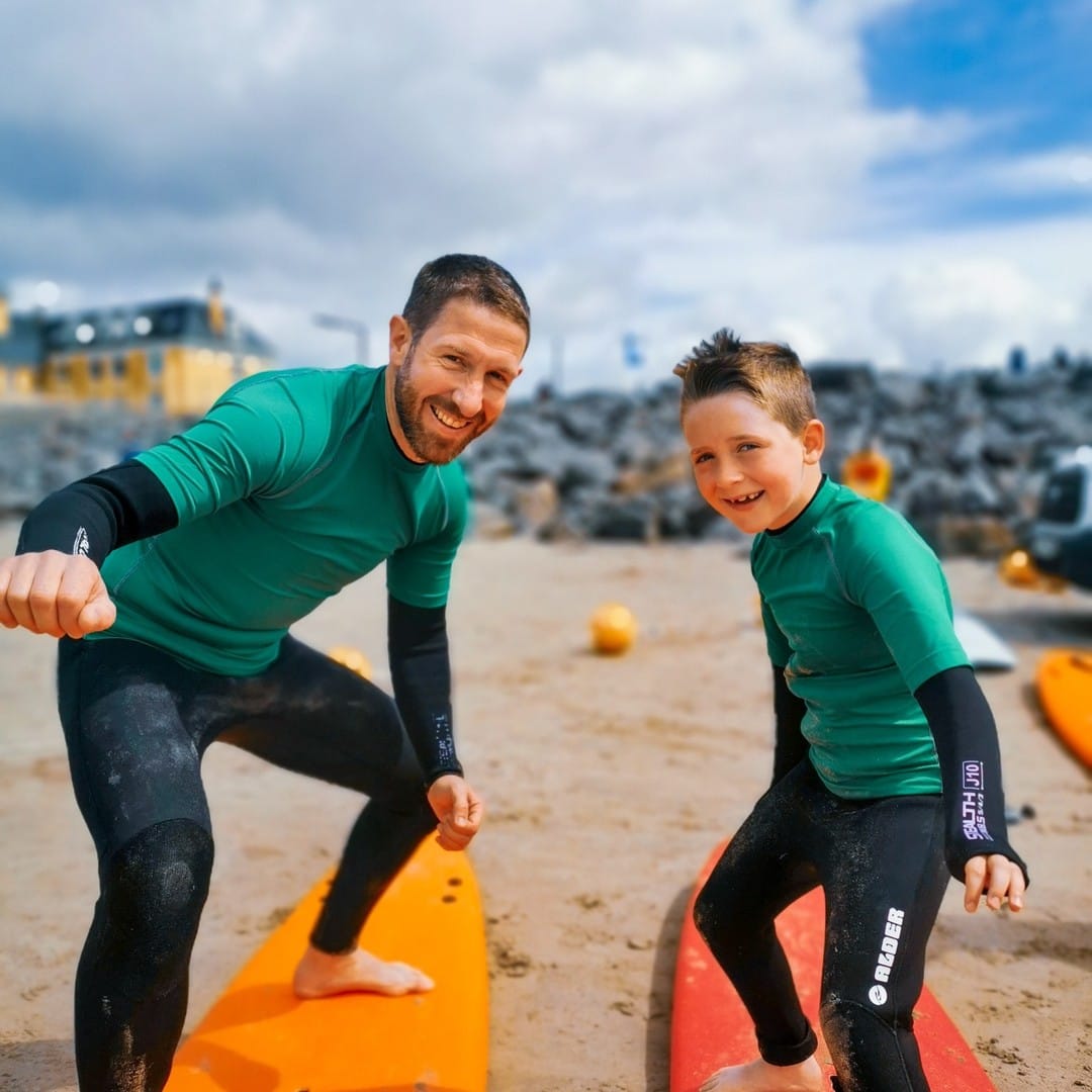 Surf instructor providing individual lesson to young child learning to surf at Rossnowlagh Beach