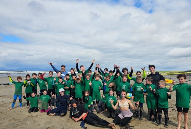 Group of children participating in summer surf camp with instructors at Rossnowlagh Beach